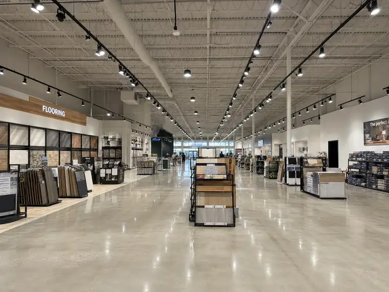 Big-box retail sales floor with track lighting and high bays on an open structural ceiling